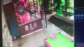Wild monitor lizard walks through bar sending terrified customers running away