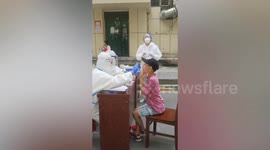 Schoolboy salutes and thanks medical staff after completing coronavirus test in China