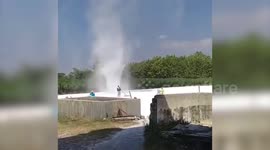 Workers try to fight dust devil tornado ripping through flour processing plant in Indonesia