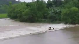 Tuk tuk driver clings on to vehicle washed away by river during heavy rain in the Philippines