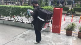 Thai delivery man walks around with huge backpack