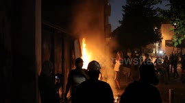 Protesters light a fire at a fence outside the parliament in Lebanon