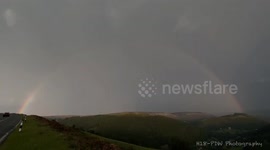 lightening strikes through a rainbow during a storm in the U.K
