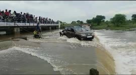 Watch - A car with four people inside it rescued by villagers from middle of heavy wave of water