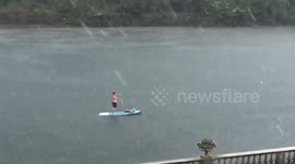 Shirtless paddleboarder ignores hailstorm battering Twickenham as he cruises along Thames