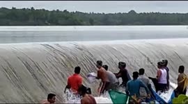 Indian villagers take advantage of flood waters to easily scoop up fish