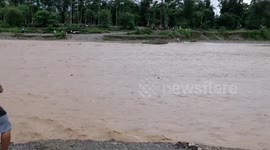 Teachers stranded by flooded river after heavy rain in the Philippines