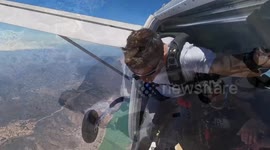 Skydiver jumps from a plane while riding a snowboard