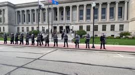 Kenosha police in full riot gear step outside of the county court in front of the Civic Center. Protesters are telling the police this is a peaceful protest. One officer can be seen on the roof.