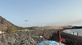 Beachgoers watch as hydroplane collect water in Spain