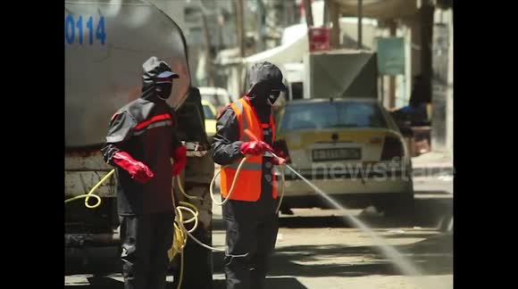 Palestinian workers spray disinfectant on roads and buildings as Gaza lockdown continues