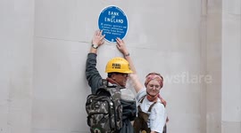 Climate change activists climb plinth and glue themselves to the Bank of England.