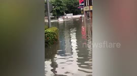 Vehicle almost tips over as driver battles through flooded street in Malaysia
