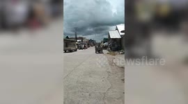 Landspout tornado stretches down from storm clouds in the Philippines