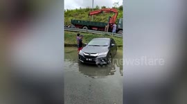 Water-damaged car towed away amid floods in Malaysia