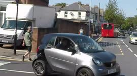 Driver fails to give way to cyclist in front of police car just to do seat belt.