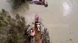 Buses filled with stones pushed into flooded river to fill dam breach in China