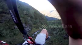 Speed flyer follows river down Austrian Alps inches away from treetops