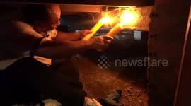 Snake catchers use huge candles to force a cobra out from hiding place in Thailand