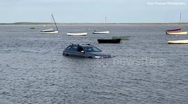 Hapless driver gets unfortunate surprise as he finds his car almost fully submerged underwater - with YACHTS sailing past it