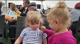 Tots at a county show putting on lipstick