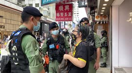 Police stopped and checked a passerby after she chanted the anti-Hong Kong police slogans in Causeway Bay during the China National Day protest.