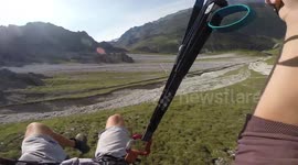 Slovakian speed flyer skims ground as he descends down Austrian mountain