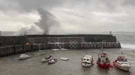 Waves crashing over the harbour wall in Clovelly Village during Storm Alex