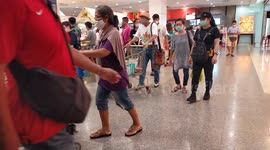 People in a shopping mall all wearing protective face masks.