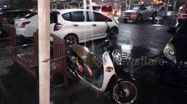Unlucky motorcycle parking under a drain pipe during a very stormy night.