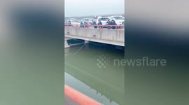 Chinese motorist fishes in river after getting stuck in traffic on highway during China's National Day holiday