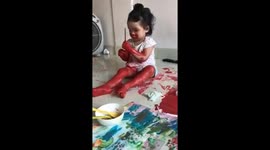 3-year-old Vietnamese girl covers herself in red paint when father concentrates on painting