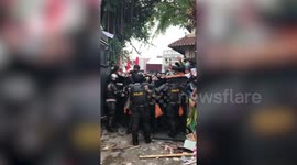 Riot police hold back crowd during protest over jobs law in Indonesia