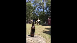 Texas cowboy bullwhips lid off bottle which standing 30 feet away