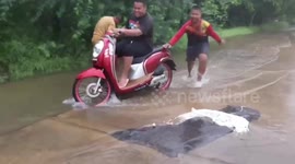 Motorcycle rider takes little brother 'wakeboarding' on flooded road