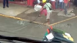 Huge python emerges on busy street after being flushed out of the drains during storm in the Philippines