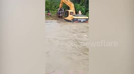Motorcycle riders carried across swollen river during floods in Cambodia