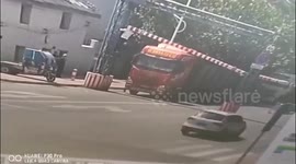Chinese man lifts up height restriction barrier to let trucks drive through underneath