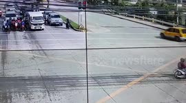 Dozey cyclist pedals through red light straight into the path of cars pulling away from junction in Philippines