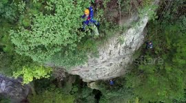 Volunteers abseil to clean litter on cliff face at Chinese scenic area