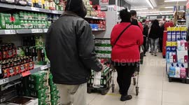 Man dancing on a supermarket line with a bottle of white rum in his hand