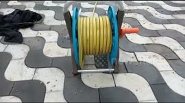 Hilarious moment small snake flees from coiled hose pipes