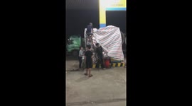 To protect gas stations, a shop owner in Vietnam had to wrap his canvas around a gas station before the Molave storm hit the mainland