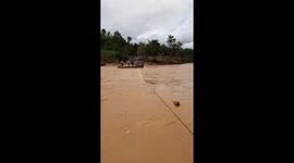 Bridge was washed away after the Molave storm, people had to stretch steel wires on both sides to be able to swim across the fast flowing river in Vietnam.