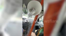 Filipino taxi driver sealed by barriers connects tube to air-con fan so passengers stay cool