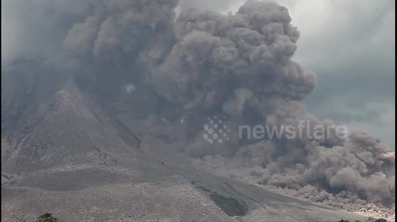Indonesian locals gather to watch active volcano Sinabung spew thick ash into the air