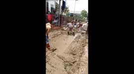 Road was deep in mud after Molave storm. People in Vietnam had to work hard to clean and even use bulldozers.