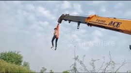 Indian man lifted 40 feet in the air by crane to rescue cow from marshy land