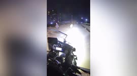 Kind motorcyclist escorts boy cycling home in darkness using headlights in China