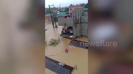 Heartwarming moment family stranded by floods shout with delight when neighbours send them food in a pulley